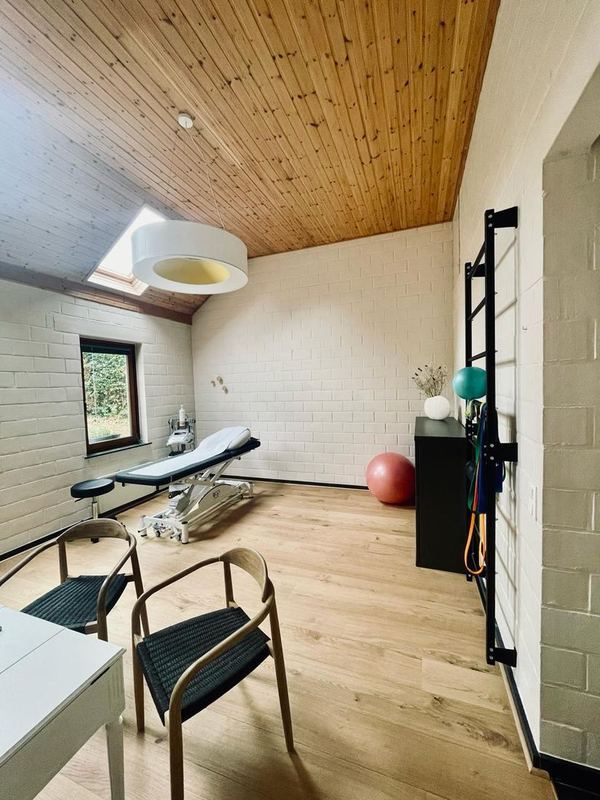 Salle de soins du cabinet de Chaumont-Gistoux avec table de traitement et espalier